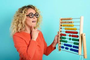 Girl with abacus is confused about the sum . cyan background photo