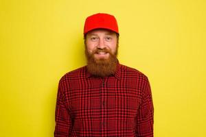 Delivery man with hat and beard has an happy expression photo