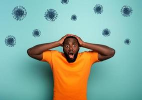 Fearful expression of a boy who is scared to catch the coronavirus. Cyan background photo