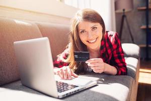 Girl is ready to pay with credit card on an online store photo