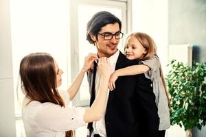 Happy little girl play with her mother and father photo