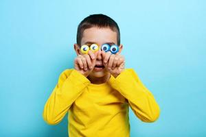 Child plays with a toy. Concept of imagination, creativity. Cyan background photo