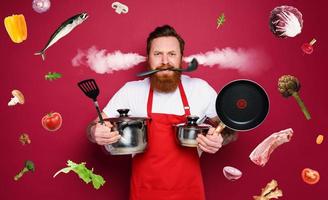 Chef hold a lot of pots. he is stressed due to overwork. red background photo