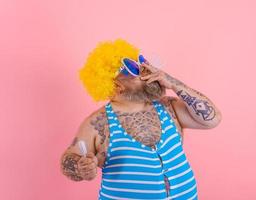 Fat man with beard and wig smokes cigarettes photo