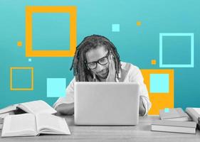 Student studies with his laptop with a desk full of books. Concept on online exam photo