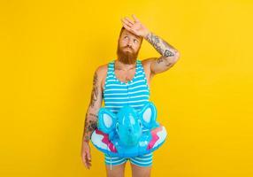 man with inflatable donut with elephant is ready to swim photo