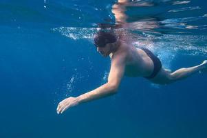 Sporty man swims fast in the sea photo