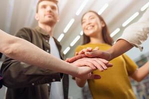 Universidad estudiantes poner su manos juntos. concepto de trabajo en equipo y camaradería foto