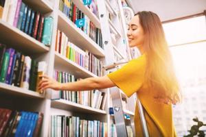 Girl choose a book to read. Concept of culture and studying. photo