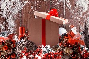 Christmas gift box presented in the middle of Christmas decorations on wooden planks photo