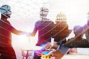 Silhouette of young workers shaking hands in the office. concept of teamwork and partnership. double exposure photo