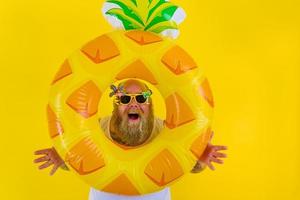 Fat amazed man with wig in head is ready to swim with a donut lifesaver photo