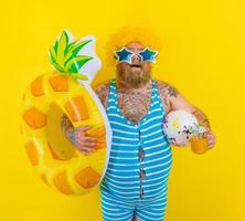 Fat amazed man with wig in head is ready to swim with a donut lifesaver photo