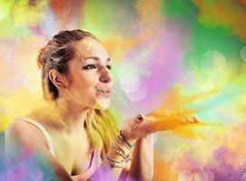 Girl blowing colored powders photo
