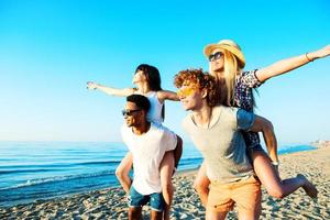 Happy smiling couples playing at the beach photo