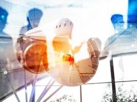 Take off of a modern aircraft and double exposure with silhouettes of passengers in the airport photo