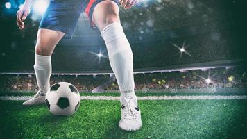 Close up of a soccer player holding the ball for a dribbling at the stadium during the night match photo