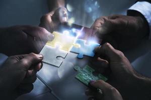Businessmen working together to build a puzzle. Concept of teamwork, partnership, integration and startup. photo