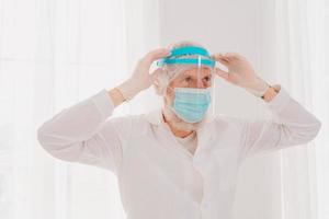Doctor with mask and face protector is ready to work in hospital photo