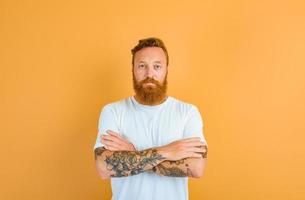 Serious man with beard, tattoo and white t-shirt photo