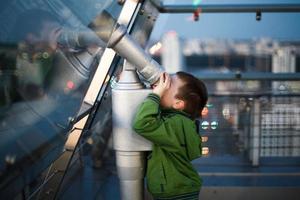 the boy is looking through a telescope photo