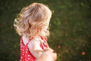 beautiful baby hair. the child holds the hand of the parent and plays photo