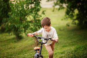 the boy is riding a bike on the street photo