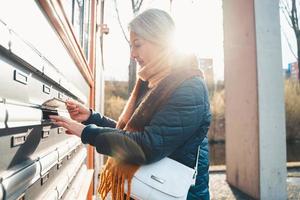 Senior woman opens the mailbox to check for new mails photo