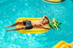 Man in swimsuit in the pool getting a tan photo