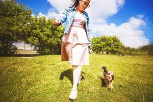 un niña es caminando con un perro en el parque. Yorkshire terrier foto