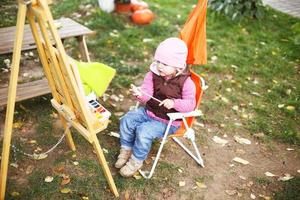 little girl draws  on the easel. the child paints photo