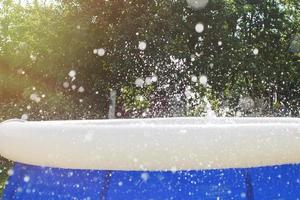 Splash of water in the swimming pool from kid jump. water splash background. photo