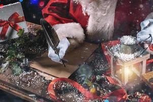 Papa Noel claus escribe un letra bueno deseos para Navidad regalos foto