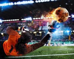 Goalkeeper catches the fireball in the stadium during a football game. photo
