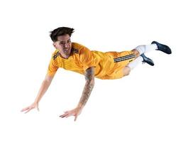 Football striker player with yellow team suit jumps photo