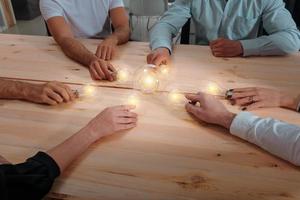 Teamwork of partners connect lightbulbs as invention a new idea photo