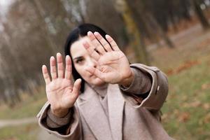 mujer estiramientos su manos con abierto palmas como un detener signo. foto