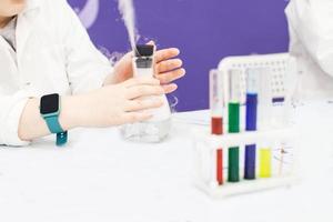 chico estudiar Ciencias educación. químico laboratorio con prueba tubos para experimentos y multicolor líquidos foto