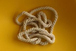 Strong white thick braided sailing or art crafting rope photo isolated on plain yellow background. Random messy placement.