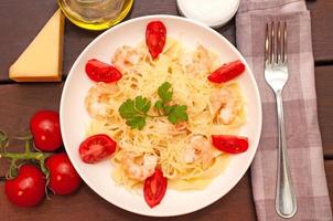 pasta con camarones, Tomates y parmesano queso foto