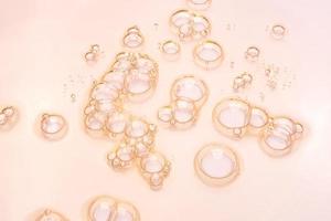 gel transparente cosmético suero petróleo muestra textura con burbujas antecedentes en rosado foto
