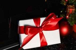 regalo en un ordenador portátil teclado cerca Navidad árbol.online compras concepto. foto