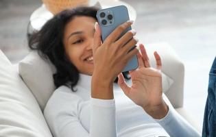 Happy freelancer girl lying on sofa and working from home. Modern technologies prefessions photo