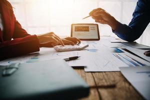 Financial analysts analyze business financial reports on a digital tablet planning investment project during a discussion at a meeting of corporate showing the results of their successful teamwork. photo