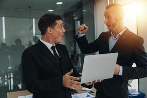 Financial analysts analyze business financial reports on a digital tablet planning investment project during a discussion at a meeting of corporate showing the results of their successful teamwork. photo