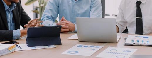 Financial analysts analyze business financial reports on a digital tablet planning investment project during a discussion at a meeting of corporate showing the results of their successful teamwork. photo