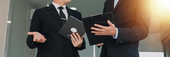 Financial analysts analyze business financial reports on a digital tablet planning investment project during a discussion at a meeting of corporate showing the results of their successful teamwork. photo