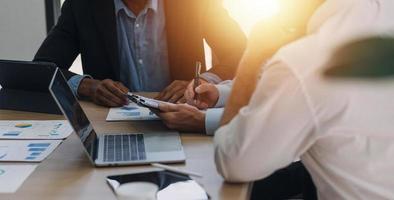 Financial analysts analyze business financial reports on a digital tablet planning investment project during a discussion at a meeting of corporate showing the results of their successful teamwork. photo