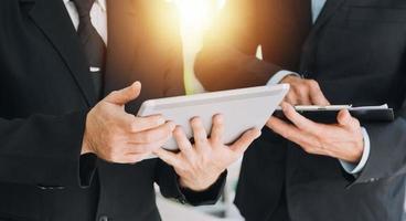 Financial analysts analyze business financial reports on a digital tablet planning investment project during a discussion at a meeting of corporate showing the results of their successful teamwork. photo