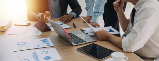 Financial analysts analyze business financial reports on a digital tablet planning investment project during a discussion at a meeting of corporate showing the results of their successful teamwork. photo
